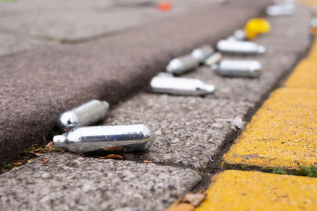 Discarded nitrous oxide bulbs, intended for making whipped cream but often inhaled for intoxication. 