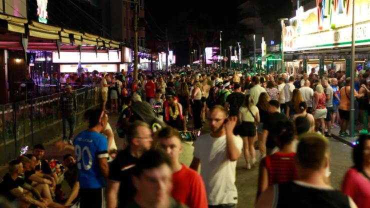 Crowds gather on a June 2023 evening on a busy street in Palma de Mallorca, Spain, where a crackdown on public partying has now been imposed.