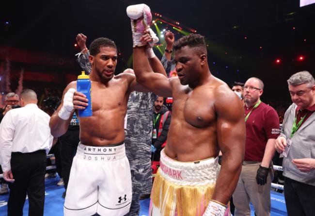 Joshua holds up the hand of a groggy Ngannou after the one-sided contest.